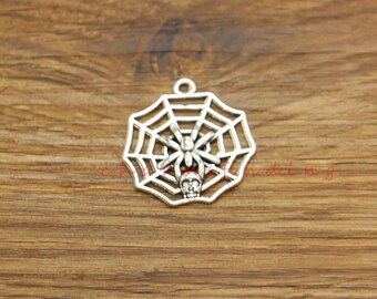 May include: Silver charm featuring a spider and skull in a web design.