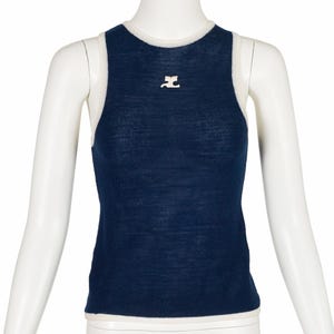 Peut inclure: Un d&eacute;bardeur bleu marine avec une bordure blanche et un petit logo blanc sur la poitrine. Le haut sans manches est pr&eacute;sent&eacute; sur un mannequin. Le haut est en tissu tricot&eacute; doux.