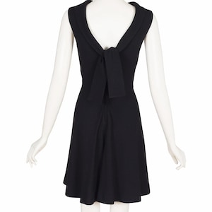 May include: A black sleeveless dress with a bow detail at the back.
