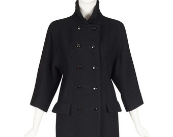 May include: A black double-breasted coat with a high collar and long sleeves. The coat has a fitted silhouette and features a row of buttons down the front.