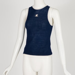 Peut inclure: Un d&eacute;bardeur bleu marine avec une bordure blanche et un petit logo rose sur la poitrine. Le haut sans manches est pr&eacute;sent&eacute; sur un mannequin. Le haut est en tissu tricot&eacute;.