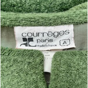 Puede incluir: Un su&eacute;ter verde con una etiqueta blanca que dice "Courr&egrave;ges Paris made in France" y una etiqueta de talla que dice "A".