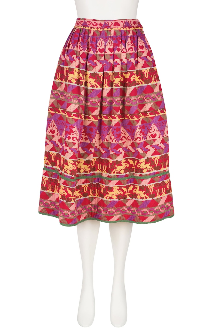 May include: A red, pink, yellow, and green patterned skirt with a geometric design. The skirt has a gathered waist and a flared silhouette.