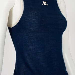 Peut inclure: Un d&eacute;bardeur bleu marine avec une bordure blanche autour de l'encolure et des emmanchures. Un petit embl&egrave;me blanc est centr&eacute; sur la poitrine. Le haut est pr&eacute;sent&eacute; sur un mannequin.