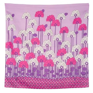 Puede incluir: Textil rectangular con un estampado floral. El diseño presenta flores estilizadas en tonos rosa y blanco sobre un fondo lavanda. Los tallos son morados y el borde es de un rosa más oscuro con un patrón geométrico.