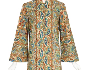 May include: A vintage paisley print dress in shades of orange, teal, and blue. The dress features a mandarin collar and long, flared sleeves. The fabric is patterned with a repeating paisley design.