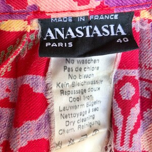 May include: A black and white care label with the text "MADE IN FRANCE ANASTASIA PARIS 40" and instructions for washing, bleaching, ironing, and dry cleaning in French, German, and English.