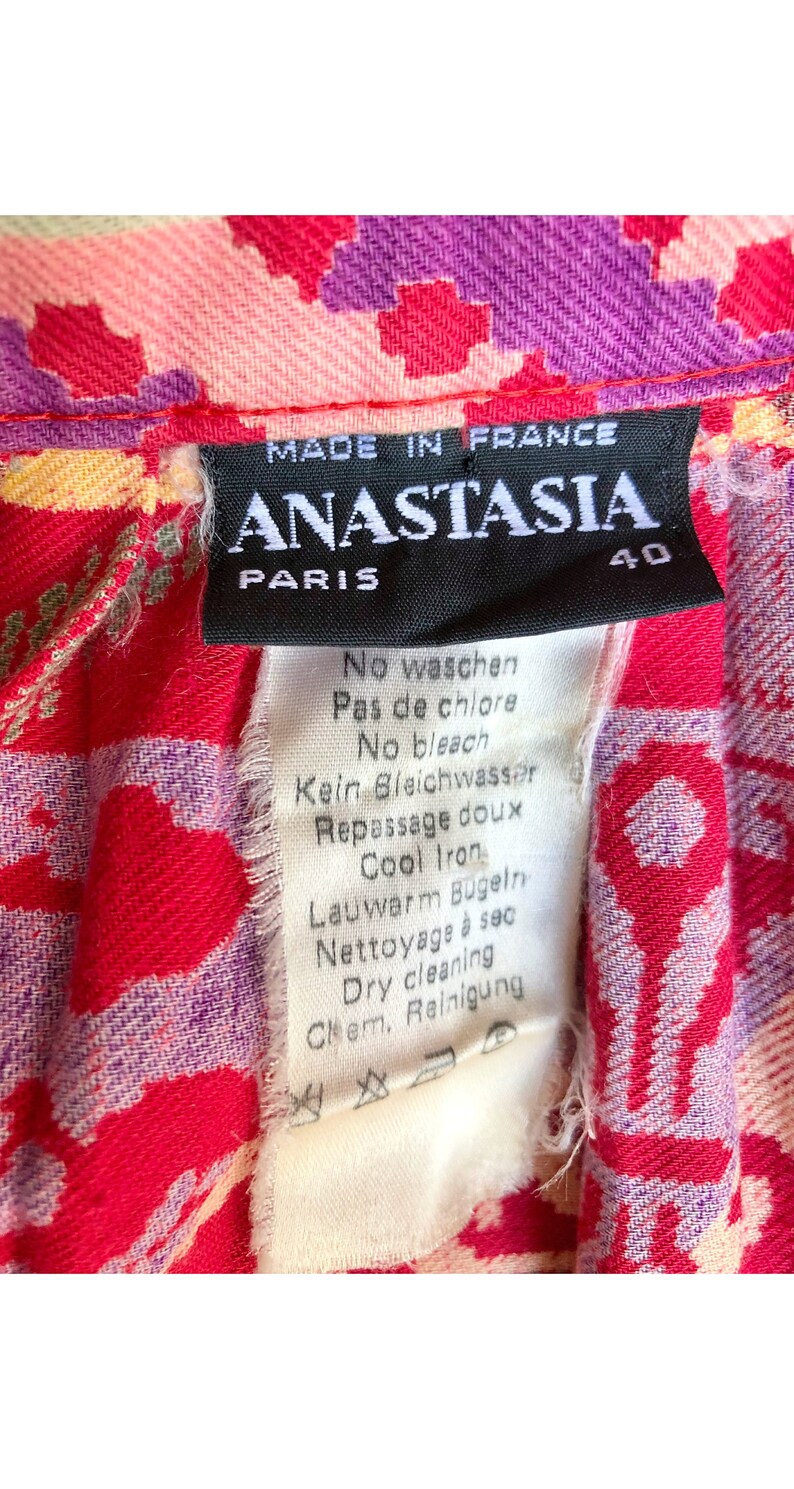 May include: A black and white care label with the text "MADE IN FRANCE ANASTASIA PARIS 40" and instructions for washing, bleaching, ironing, and dry cleaning in French, German, and English.