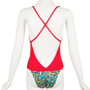 May include: Red swimsuit with a criss-cross back strap and a blue and yellow print of cartoon characters on the bottom.