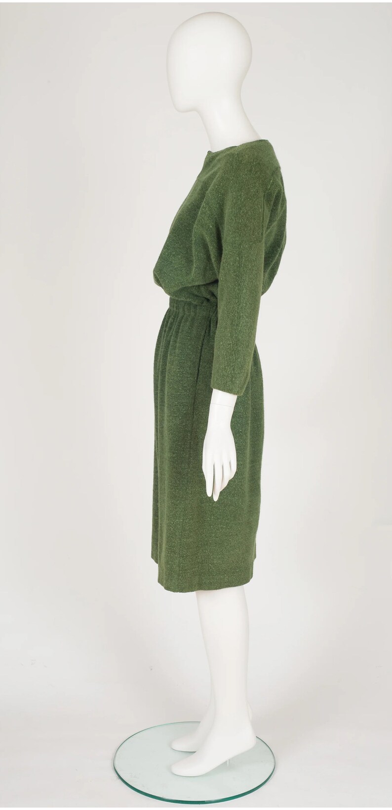 Puede incluir: Un vestido verde de manga larga con cuello redondo y cintura fruncida.