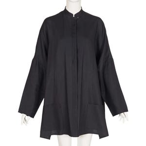 Può includere: Tunica nera a maniche lunghe con collo alla coreana e due tasche frontali. La tunica ha una chiusura con bottoni al collo e una vestibilità ampia. Le maniche sono ampie e svasate. La tunica è realizzata in tessuto leggero.