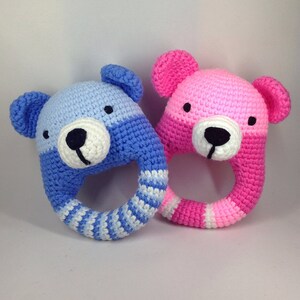 May include: Two crocheted bear rattle toys, one blue and white and one pink and white.