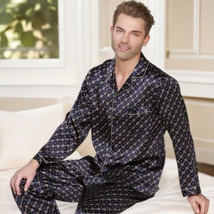 May include: A long-sleeved pajama top and pants set in a dark blue silk fabric with a geometric pattern in gold and white.
