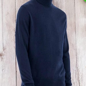 以下が含まれることがあります： 長袖の紺色のタートルネックセーターです。