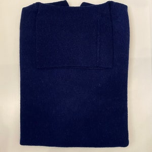 以下が含まれることがあります： リブ編みでできた、折り畳まれたネイビーブルーのセーターです。
