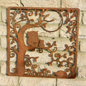 May include: Rustic metal wall art featuring a stylized tree with an owl and a cat perched on a branch. The metal is rusted and has a brown and orange color.