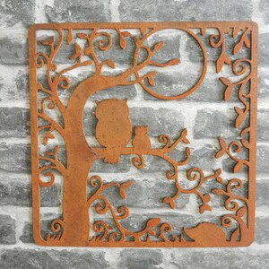 May include: Rustic metal wall art featuring an owl and two small animals perched on a tree branch with intricate leafy details. The metal has a rusty brown finish.