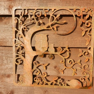 May include: Rustic metal wall art featuring a tree with two owls perched on branches. The tree is intricately designed with swirling branches and leaves, creating a whimsical and nature-inspired design. The metal is a rusty brown color, adding to the rustic charm of the piece.