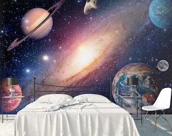 May include: A bedroom with a white bed and a space-themed mural on the wall. The mural features planets, stars, and a galaxy. There are two lamps on end tables next to the bed.