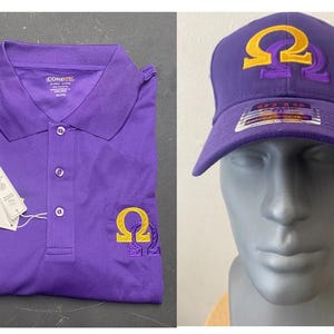 Op de afbeelding: Een paarse poloshirt en baseballcap. De shirt heeft een kraag, knopen en een geel en paars geborduurd symbool. De pet is paars met hetzelfde gele en paarse symbool op de voorkant. Beide items hebben labels.
