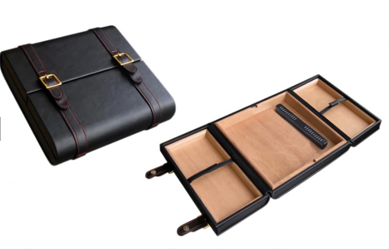 May include: Black leather case with red stitching and gold-colored buckles. The case is shown closed and open, revealing a light brown interior with compartments and a black accessory. A stylish storage solution.