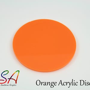 May include: A bright orange acrylic disc with a smooth surface. The disc is circular. The text "Orange Acrylic Disc" is printed in black below the disc. The logo "SA Southern Acrylics" is in the lower left corner.