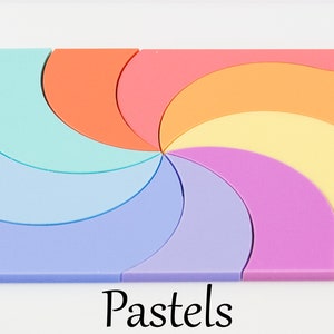 May include: A pastel-colored puzzle with a spiral design. The puzzle is made up of 8 pieces, each a different shade of pastel. The puzzle is labeled "Pastels".
