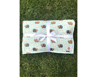 Handmade reversible cot or play blanket featuring Australian Wombats on mint green background. (Also comes in baby blue background)