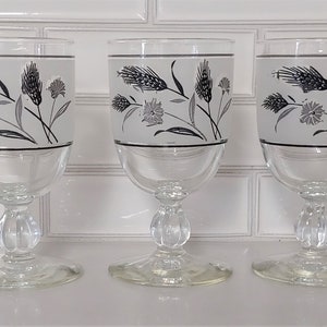 May include: Three clear glass goblets with a frosted white background and black and gray wheat and flower designs.