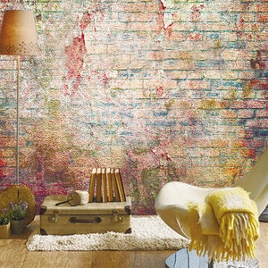 May include: A vintage-style, distressed brick wall with a white chair, a suitcase, and a lamp. The wall has a faded, colourful paint effect.