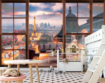 May include: A white table with a pink stool and a stuffed rat toy sits in front of a large window with a view of the Eiffel Tower and the city of Paris at sunset. The window is framed in brown wood and has a balcony with furniture outside.