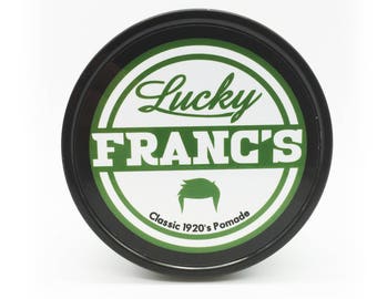 May include: A black jar with a green and white label that says "Lucky Franc's Classic 1920's Pomade". The label also features a stylized image of a man's hair.