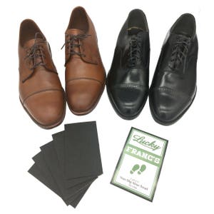 May include: Four pairs of leather shoes, two brown and two black, with a package of non-slip shoe treads labeled "Lucky Franc's Non-Slip Shoe Tread 6 pieces".