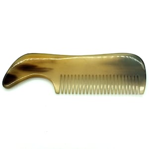 May include: A brown and tan horn comb with a curved handle. The comb has fine teeth and is designed for styling hair.