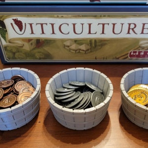 May include: Three wooden bowls filled with different colored game tokens. The bowls are labeled with the word "VitiCulture".