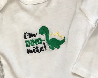 Green Dinosaur Embroidery design on a long sleeve white cotton infant bodysuit