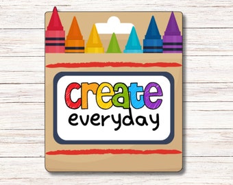 Puede incluir: Una tarjeta marrón con una ilustración de lápices de colores rojo, naranja, amarillo, verde, azul y morado. La tarjeta dice "create everyday" en letras de colores.