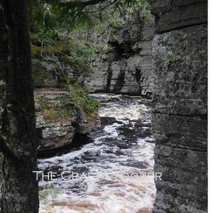 May include: A view of a rushing river flowing through a rocky canyon. The river is surrounded by lush green trees and the water is white with foam. The text "THE CRAFTS COOPER" is visible in the image.