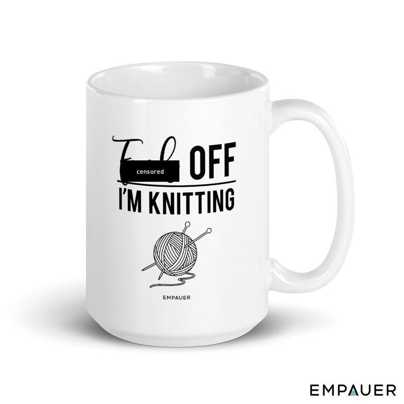 May include: White ceramic mug with a black graphic that says "F--- OFF I'M KNITTING" with a drawing of a ball of yarn and knitting needles. The text "censored" is over the first word.