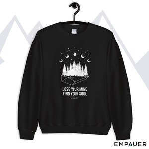 K&ouml;nnte beinhalten: Schwarzes Sweatshirt mit wei&szlig;er Grafik eines Waldes, Sternen und Halbmonden. Der Text "LOSE YOUR MIND FIND YOUR SOUL" ist unter der Grafik aufgedruckt. Der Markenname "EMPAUER" ist unten aufgedruckt.