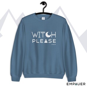 K&ouml;nnte beinhalten: Ein blauer Pullover mit dem Text "WITCH PLEASE" in Wei&szlig; mit einer Halbmondgrafik &uuml;ber dem Wort "PLEASE". Der Text "EMPOWER" steht in kleinerer wei&szlig;er Schrift unter dem Satz.