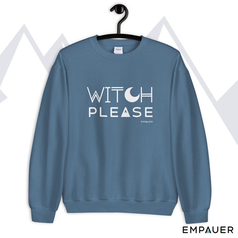 K&ouml;nnte beinhalten: Ein blauer Pullover mit dem Text "WITCH PLEASE" in Wei&szlig; mit einer Halbmondgrafik &uuml;ber dem Wort "PLEASE". Der Text "EMPOWER" steht in kleinerer wei&szlig;er Schrift unter dem Satz.