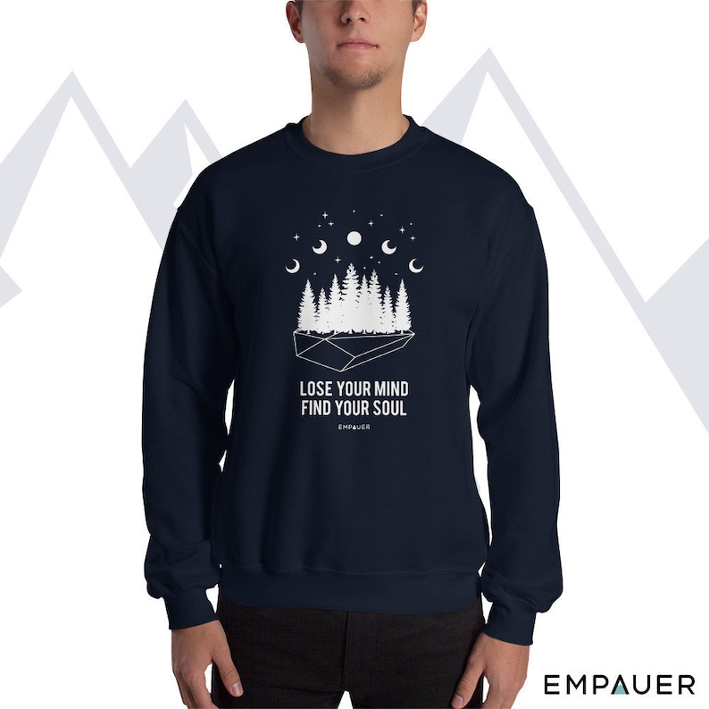 K&ouml;nnte beinhalten: Marineblaues Sweatshirt mit wei&szlig;er Grafik eines Waldes, Mondphasen und Sternen. Der Text "LOSE YOUR MIND FIND YOUR SOUL" ist unter der Grafik aufgedruckt. Der Markenname "EMPAUER" ist unten aufgedruckt.