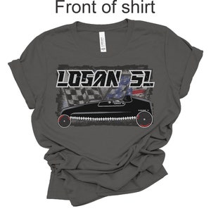 May include: A dark gray t-shirt with a vintage-style graphic of a race car with the text "LOGAN 31" above it. The car is black with red wheels and a checkered flag pattern behind it.