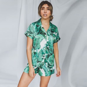 May include: A white and green short-sleeved pajama top and shorts set with a tropical leaf print.