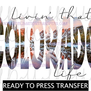 May include: A white graphic with the words "Livin' that Colorado Life" in a stylized font. The word "Colorado" is filled with a scenic mountain and lake image. The phrase "Ready to Press Transfer" is at the bottom.