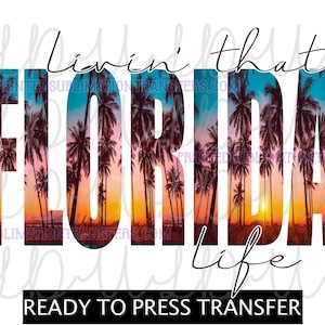 May include: A white graphic with the word "FLORIDA" in large, bold letters, filled with a sunset scene and palm trees. The words "Livin' that life" are above and below the word "FLORIDA". The words "READY TO PRESS TRANSFER" are at the bottom.