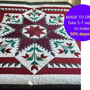 May include: A handmade quilt with a starburst design. The quilt features a central burgundy star surrounded by white, burgundy, green, and black geometric patterns. The text "MADE TO ORDER" is visible in a purple circle.