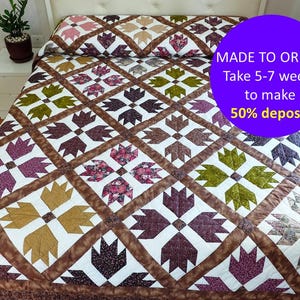 Puede incluir: Una colcha blanca con un patrón de huellas de patas en tonos marrones, verdes y morados. La colcha se hace por encargo y tarda de 5 a 7 semanas en hacerse. Se requiere un depósito del 50%.