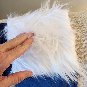 May include: A close-up of a blue and white baseball stocking. The top portion is white faux fur, and the bottom is blue fabric. Baseball-themed decorations are visible at the bottom of the stocking.